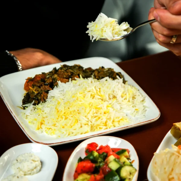side-view-rice-with-stewed-meat-herbs-wooden-table