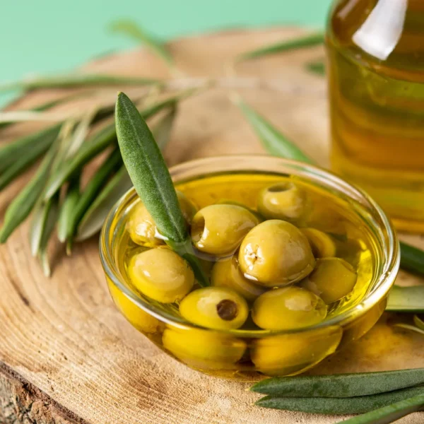 virgin-olive-oil-bottle-green-olives-green-background